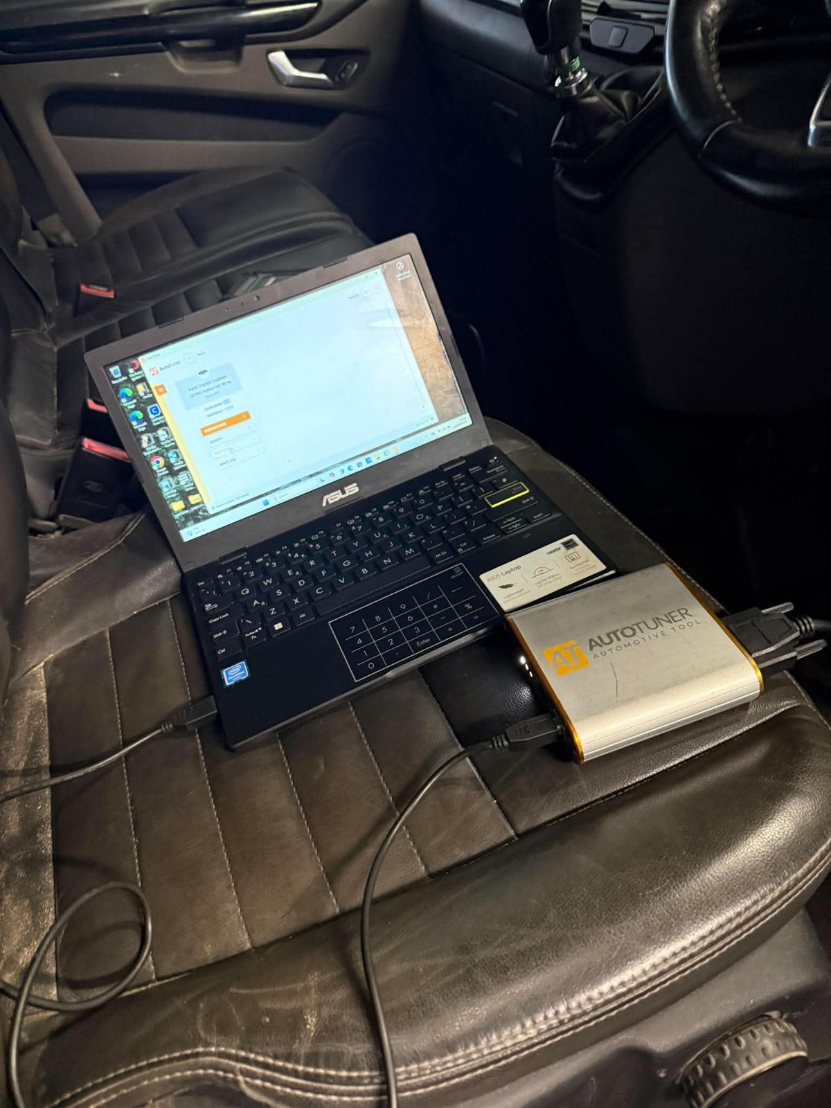Laptop on car seat with connected external hard drive inside vehicle