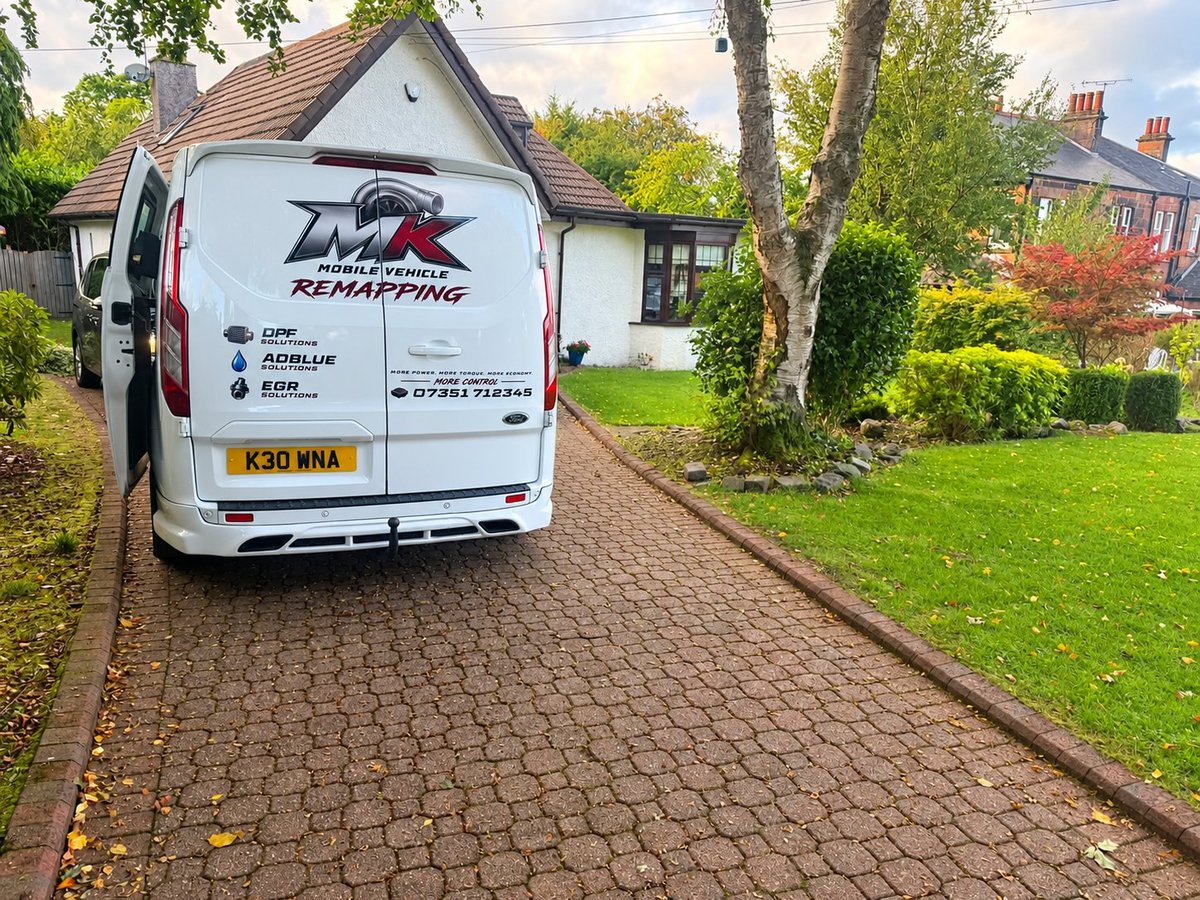 White service van with ECU remapping branding parked on brick driveway in front of residential house